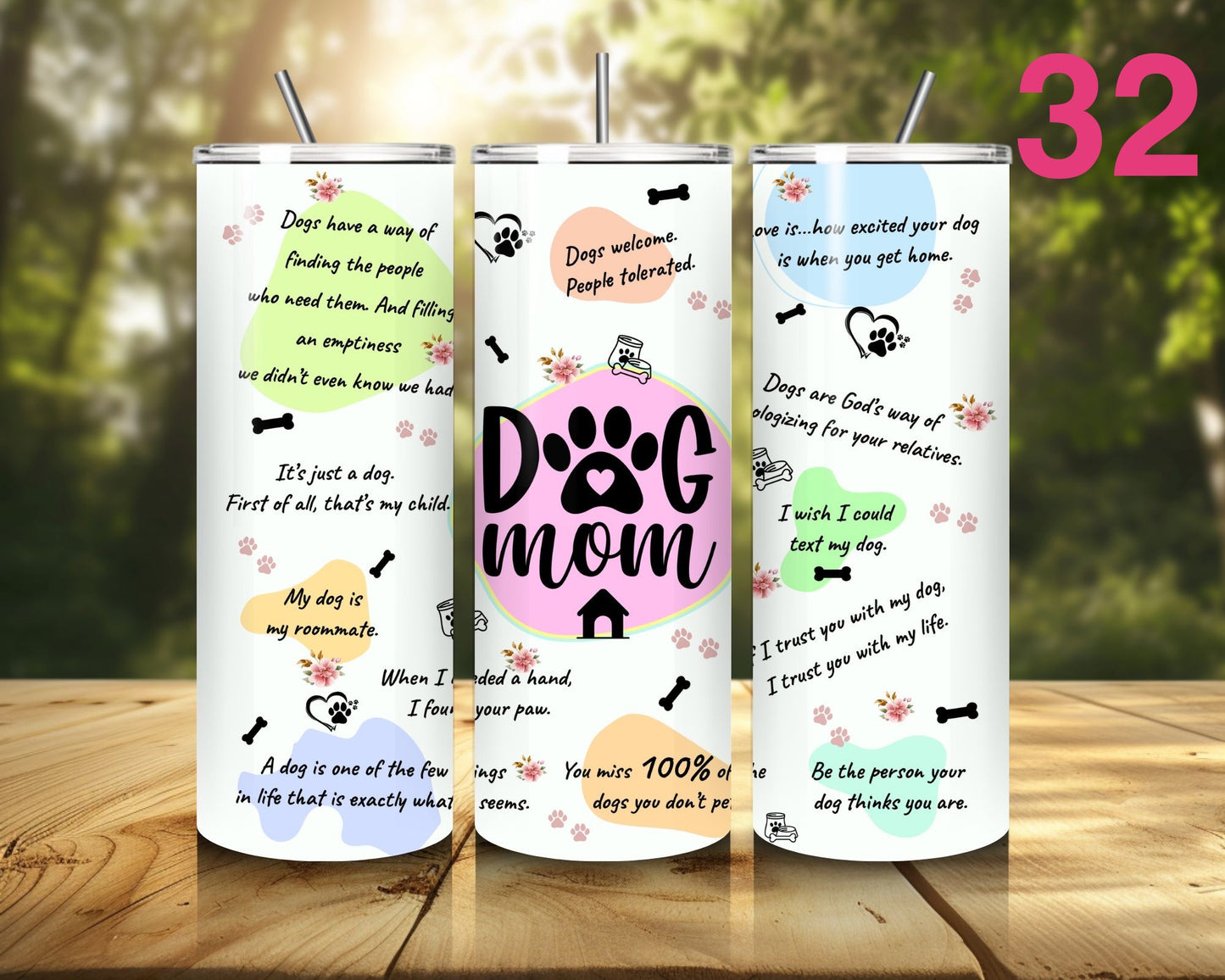Three tumblers with dog-themed designs on a wooden surface with a blurred natural background.