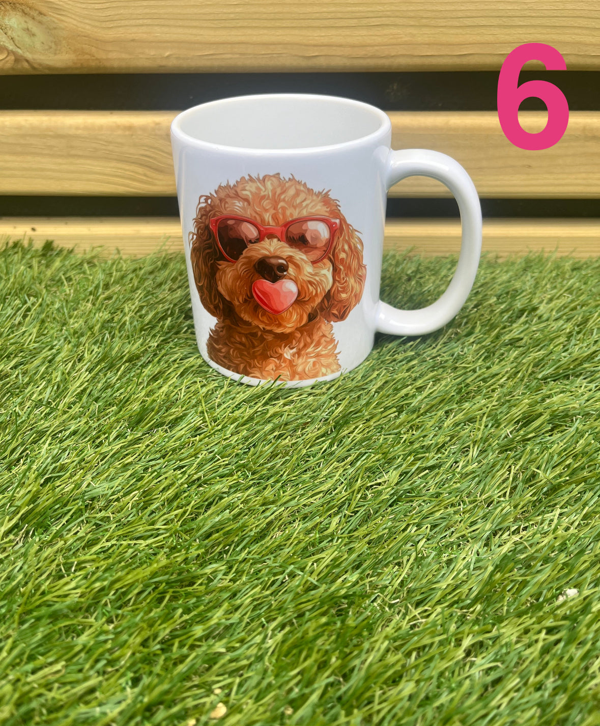 White mug with a dog design wearing sunglasses on grass