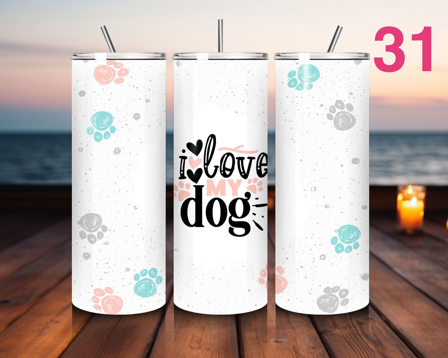 Three white tumblers with paw print designs and 'I love my dog' text on a wooden surface with ocean view.