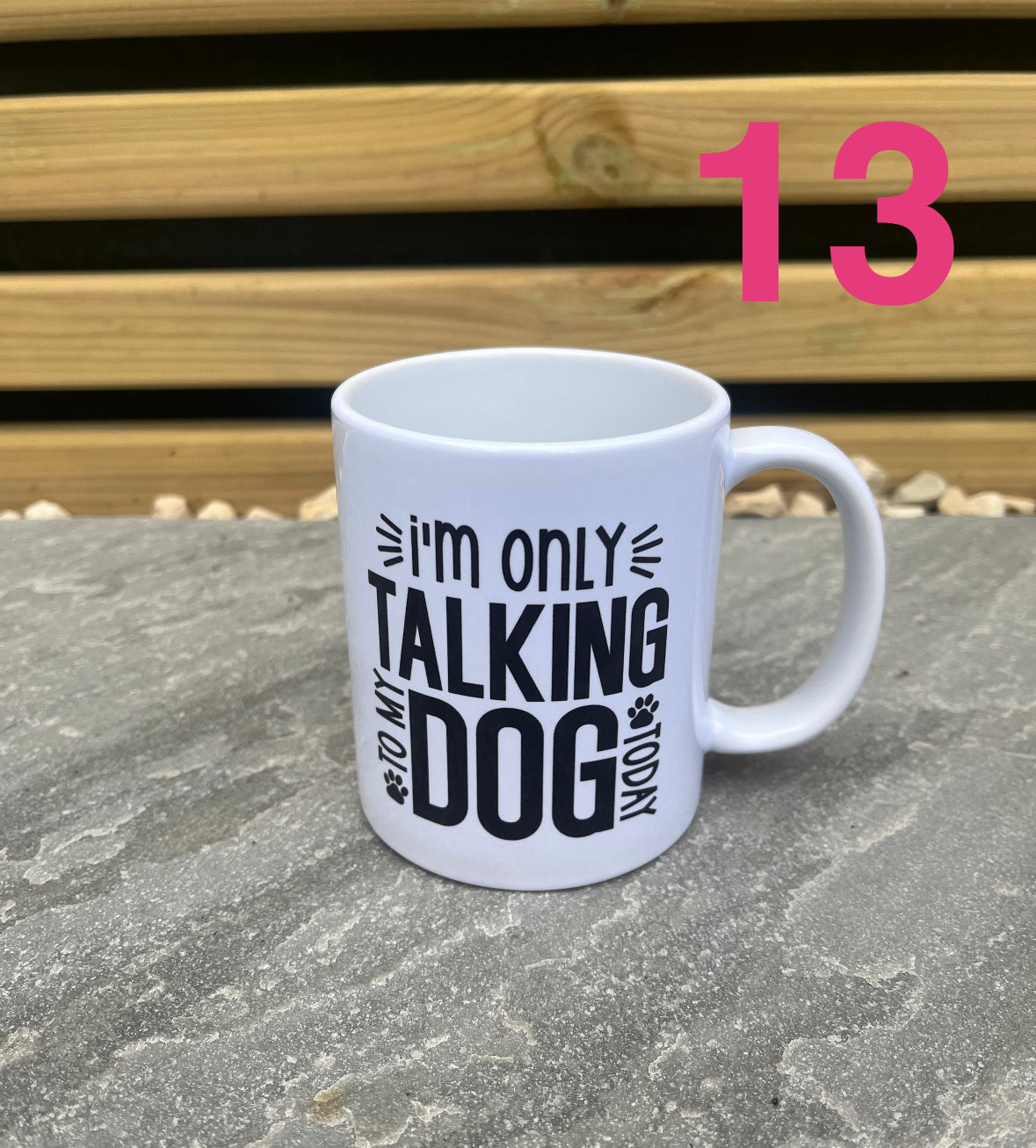 White mug with text on a stone surface with a wooden background