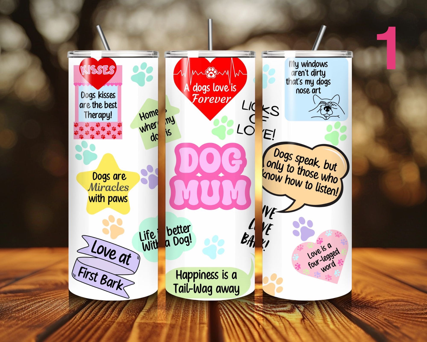 Three tumblers with dog-themed designs on a wooden surface.