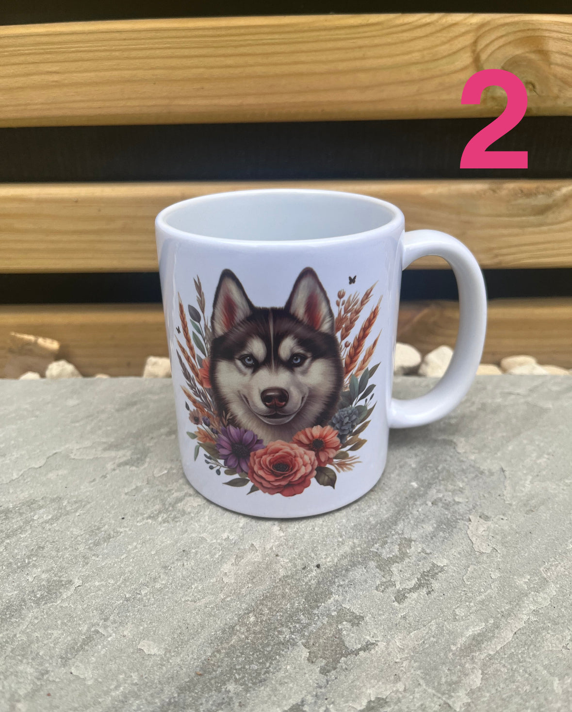 Mug with a husky dog design and floral elements on a stone surface.