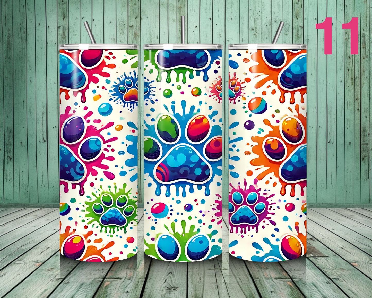 Three colorful tumblers with paw print design on a wooden floor.