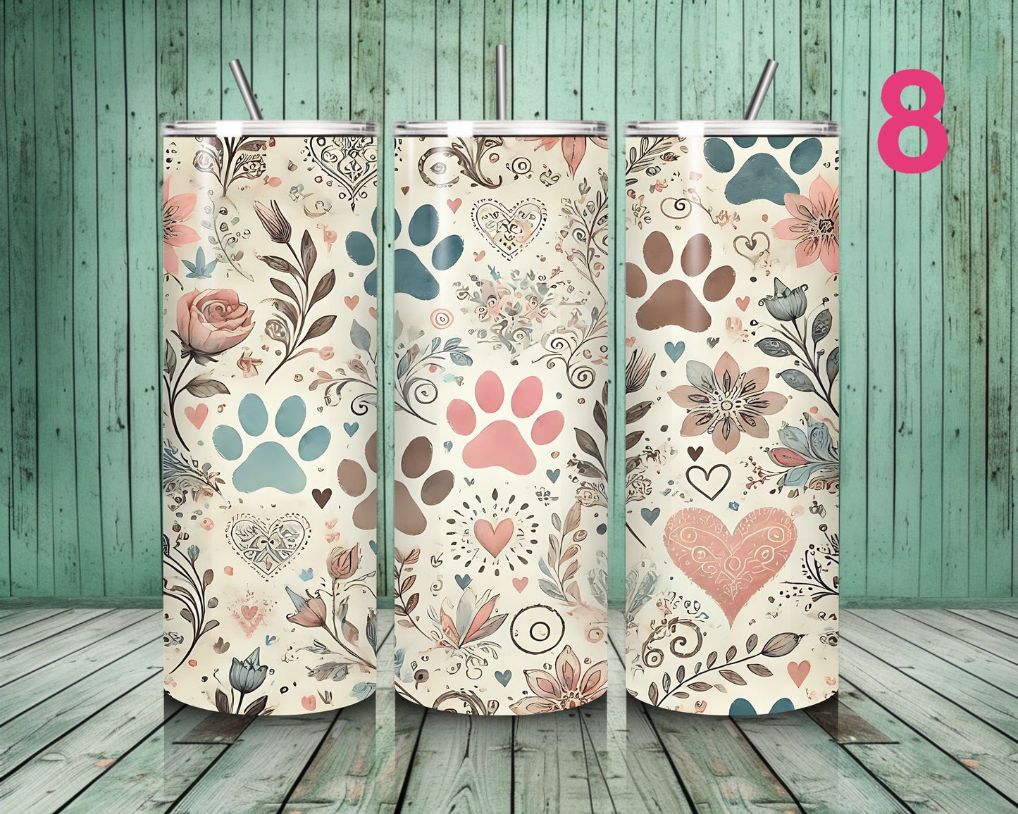 Three floral-patterned tumblers with decorative designs on a wooden floor.