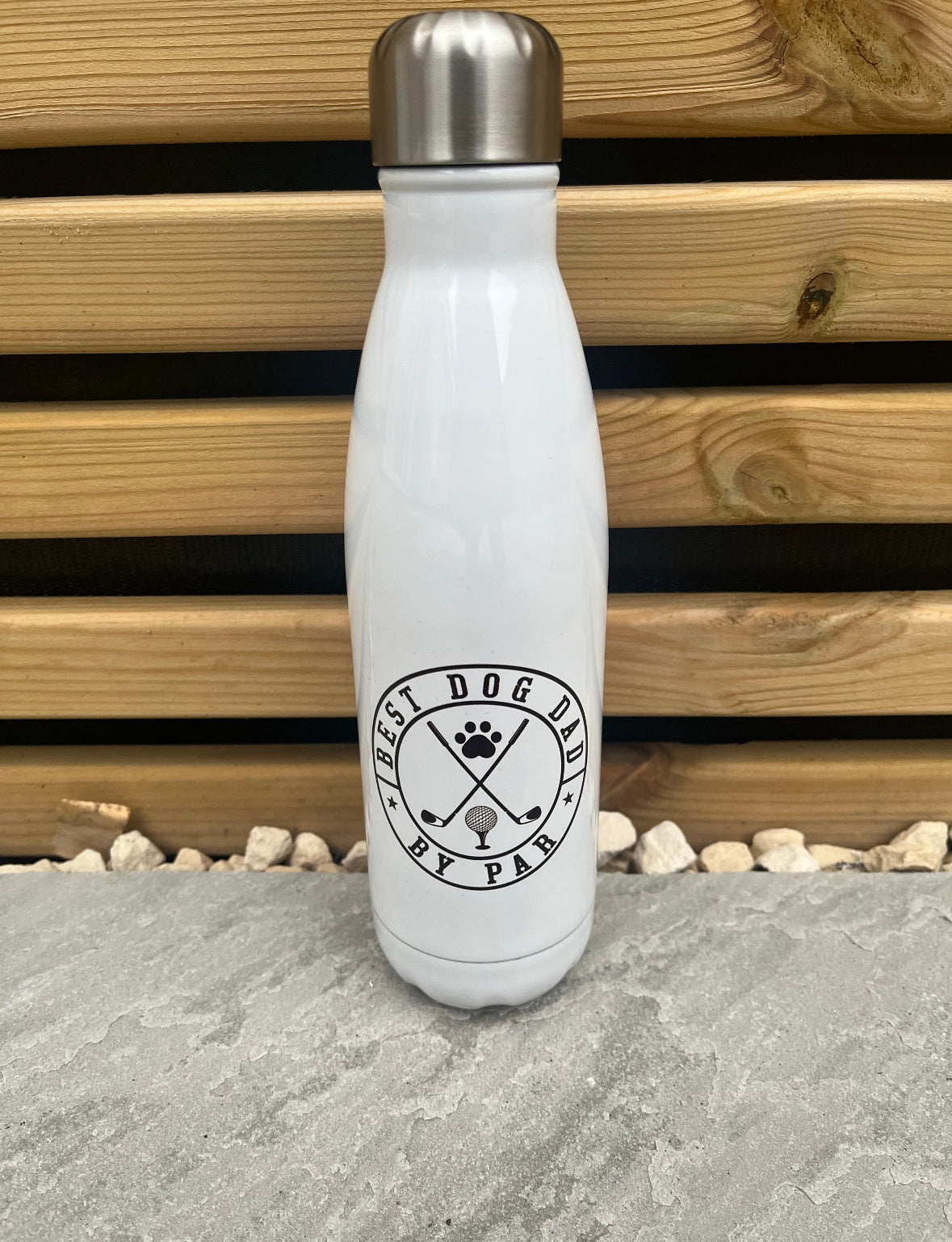 White insulated bottle with black logo on a stone surface with wooden background