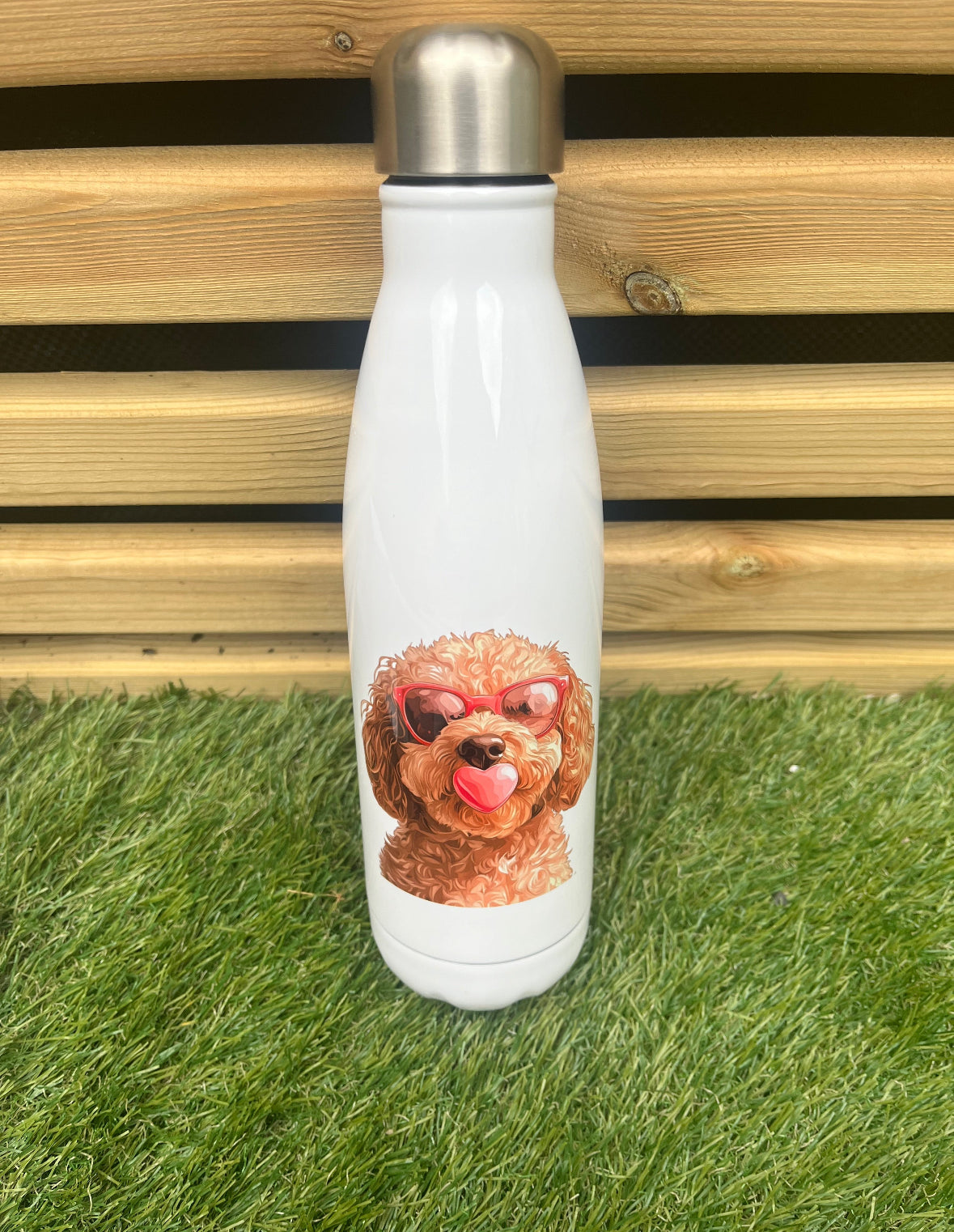 White water bottle with a dog design on grass and wooden background