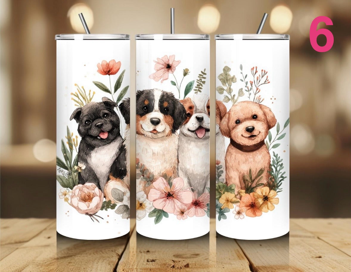 Three tumblers with illustrations of puppies and flowers on a wooden surface.