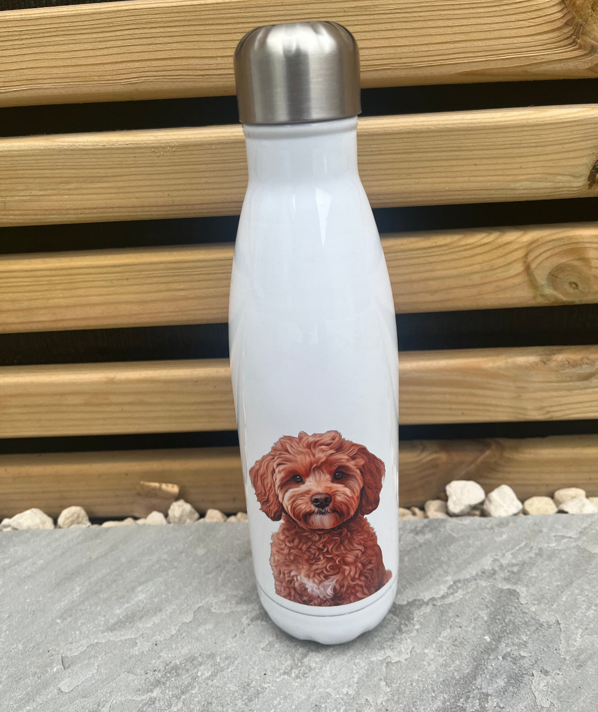 White water bottle with a red dog illustration on a stone surface with a wooden background