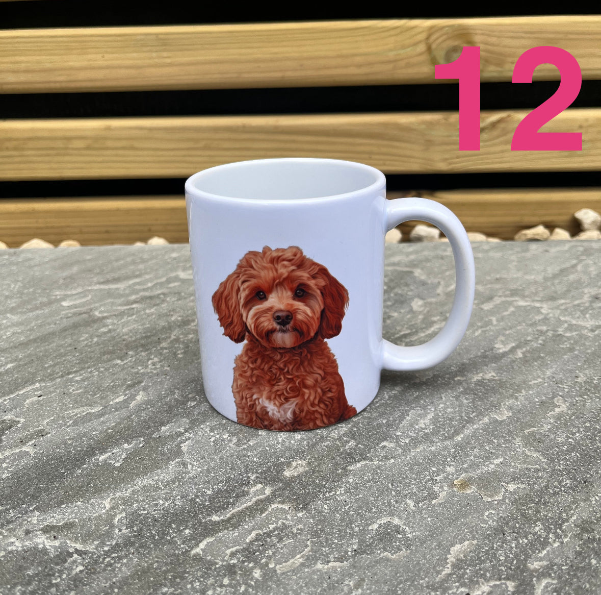 White mug with a brown dog illustration on a stone surface with a wooden bench in the background.