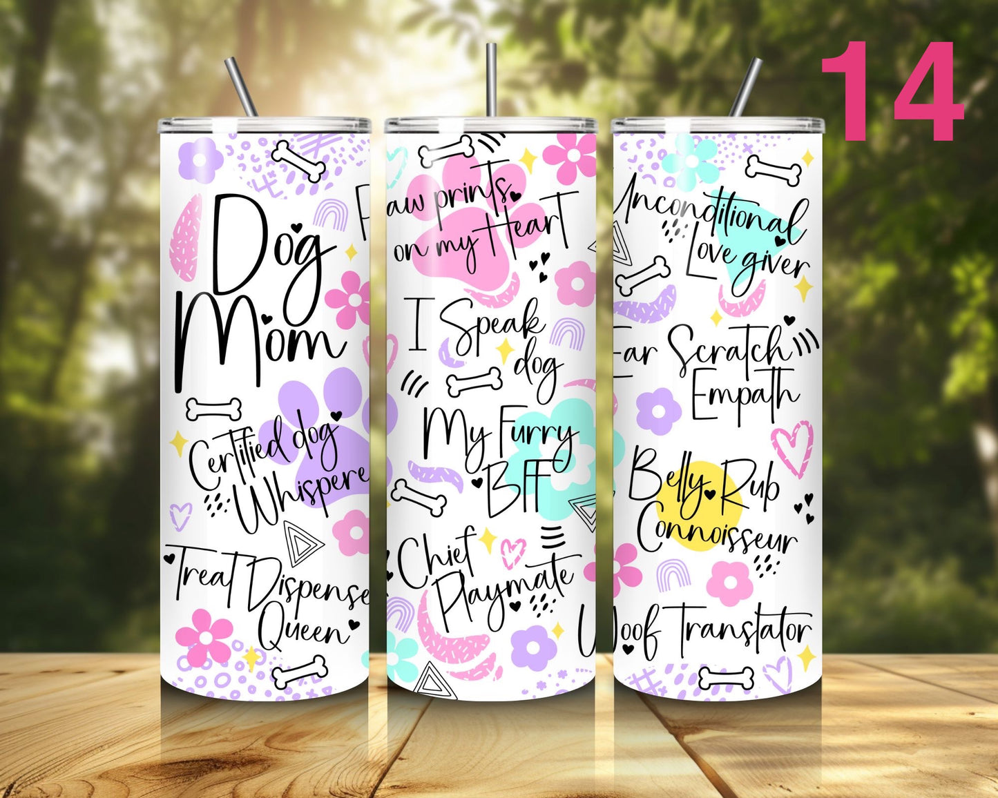 Three tumblers with dog-themed text designs on a wooden surface with a blurred natural background.