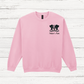 Pink sweatshirt with a bulldog graphic and text on a wooden surface