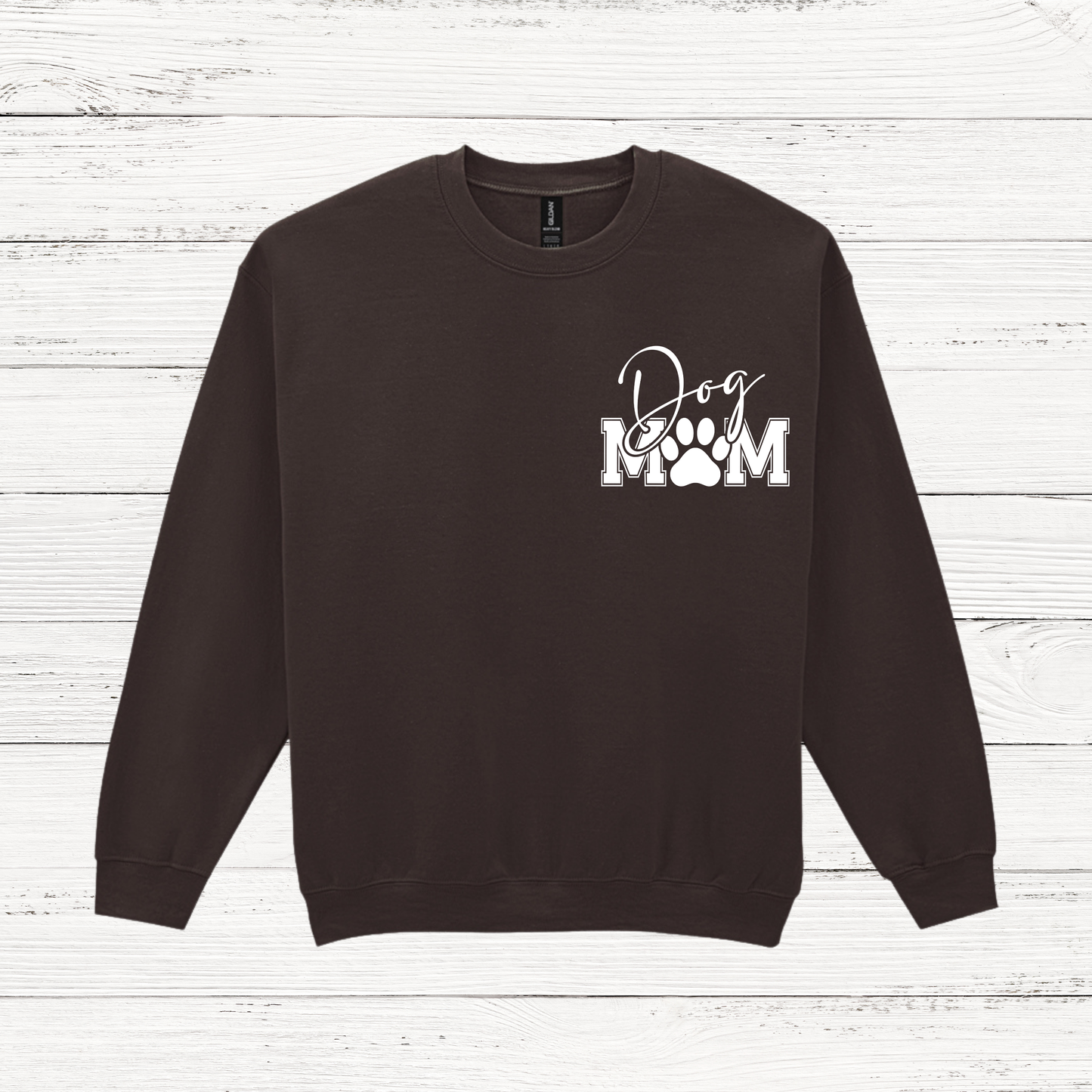 Black sweatshirt with 'Dog Mom' text on a wooden surface