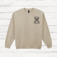 Beige sweatshirt with a dog illustration and text on a wooden surface