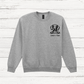 Gray sweatshirt with a dog illustration and text on a wooden surface