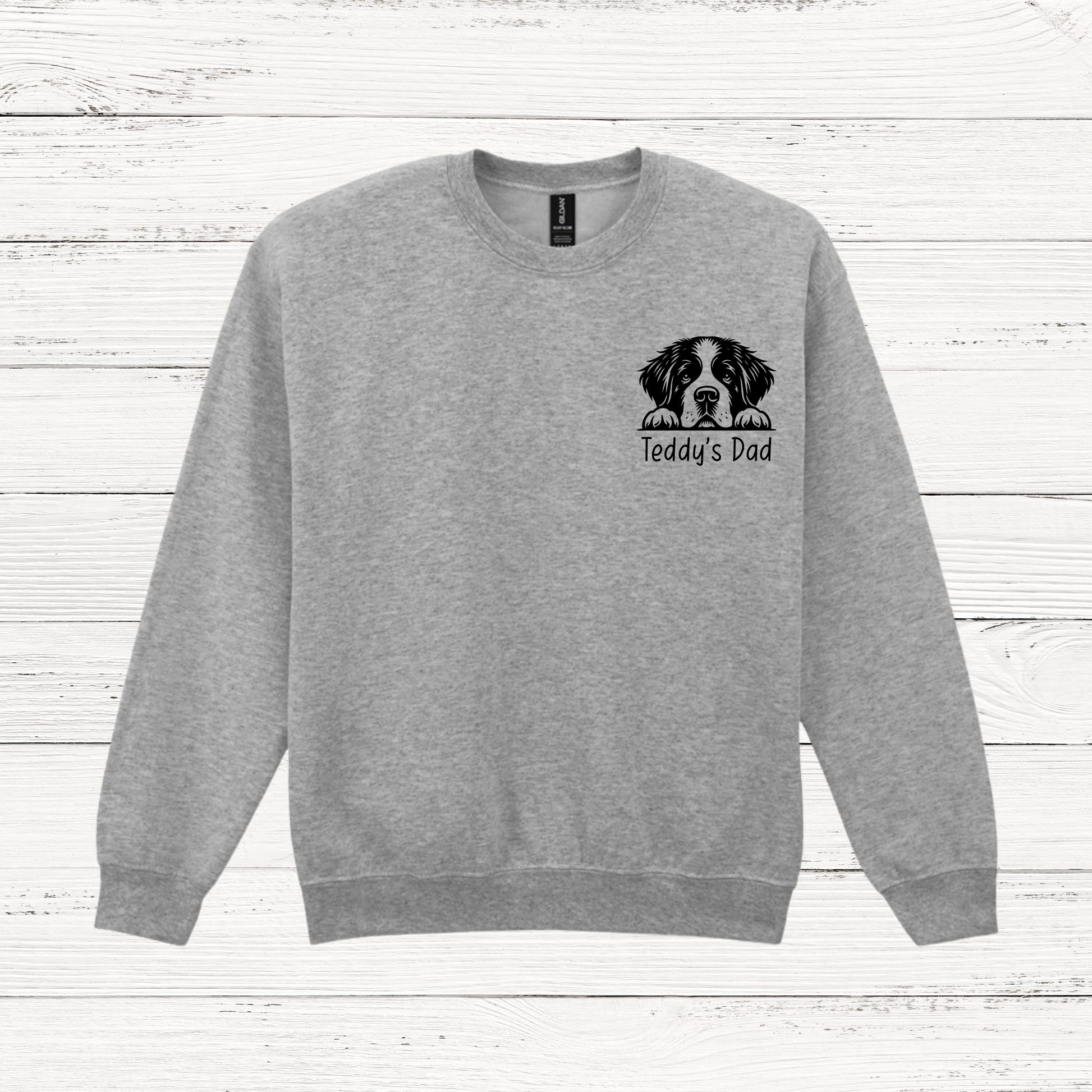 Gray sweatshirt with a dog illustration and text on a wooden surface