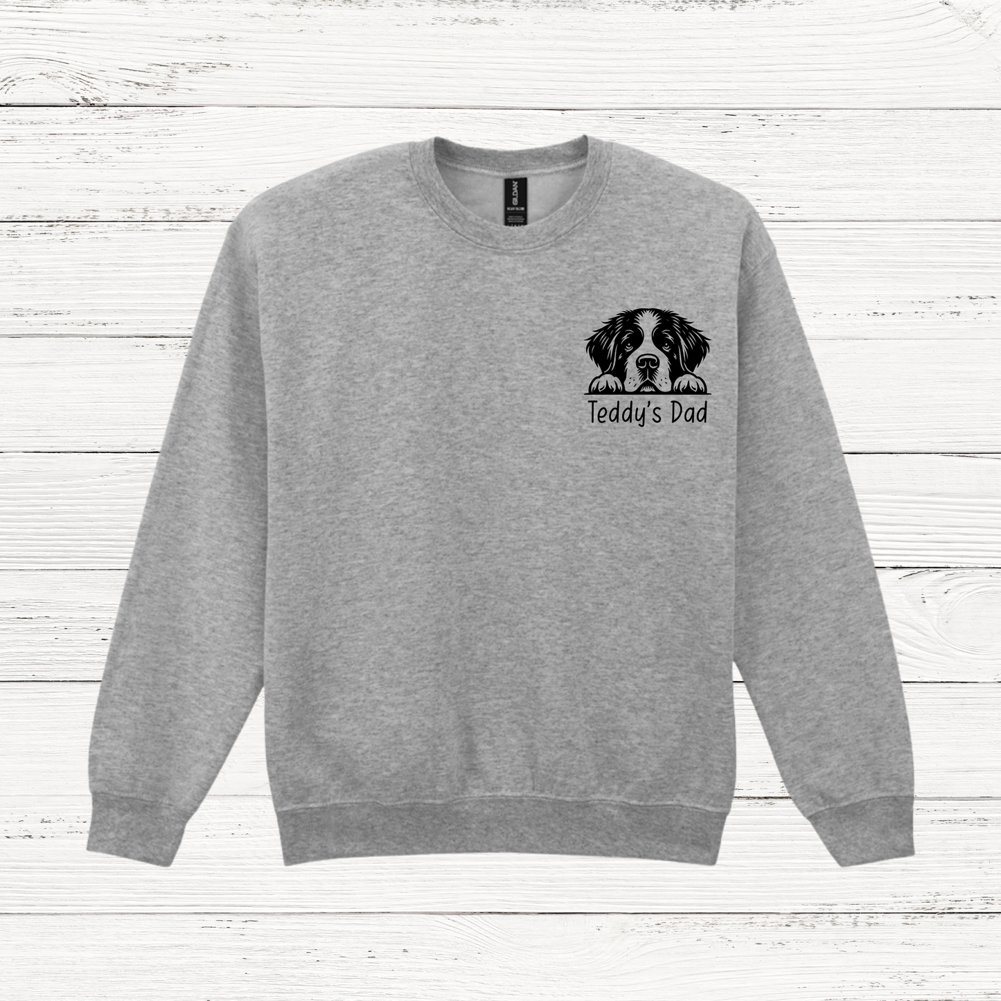 Gray sweatshirt with a dog illustration and text on a wooden surface