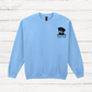Light blue sweatshirt with a dog graphic and text on a wooden surface
