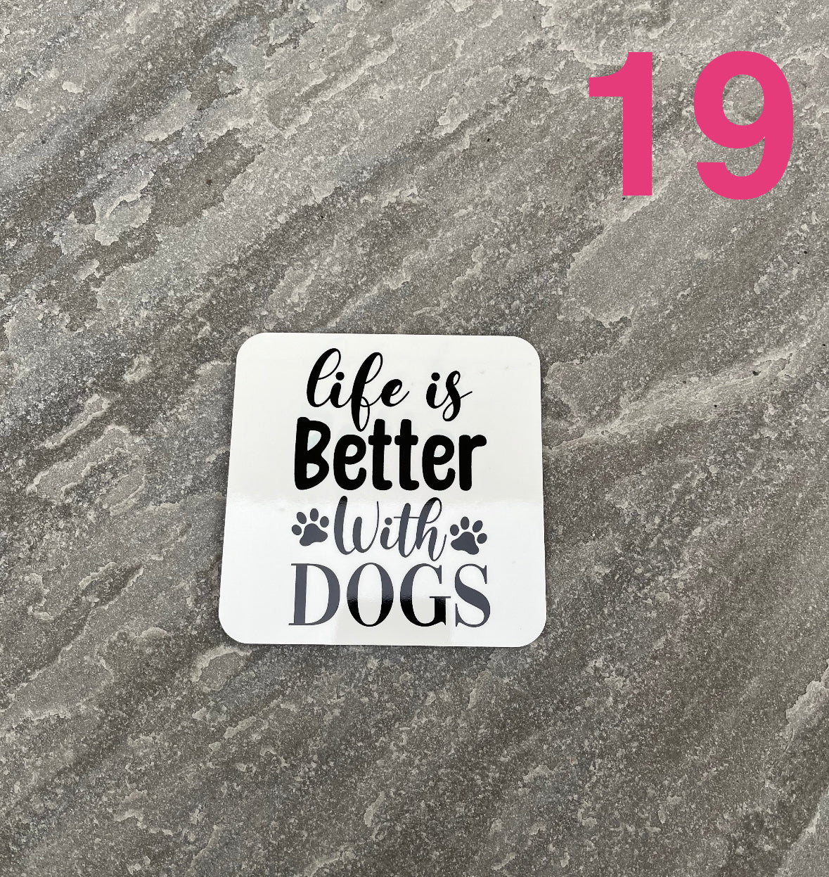 Sticker with 'Life is Better With Dogs' text on a textured gray background