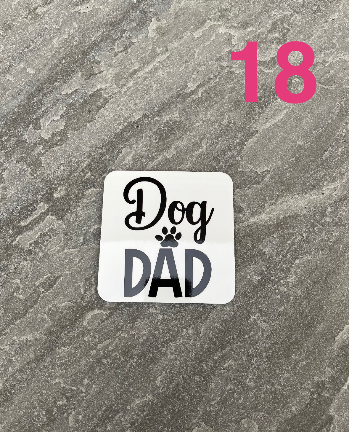 Sticker with 'Dog Dad' text on a textured gray background