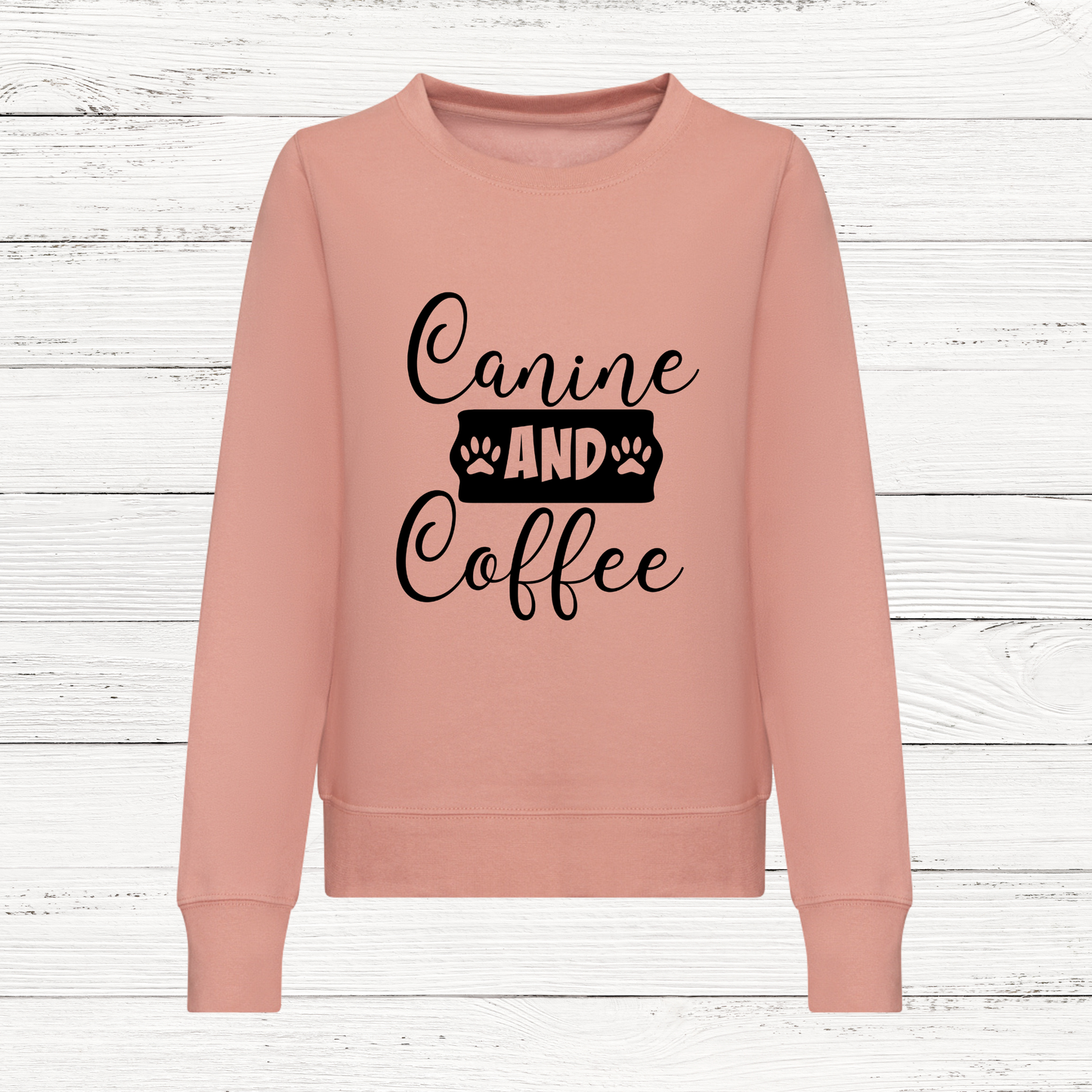 Pink sweatshirt with 'Canine and Coffee' text on a wooden background