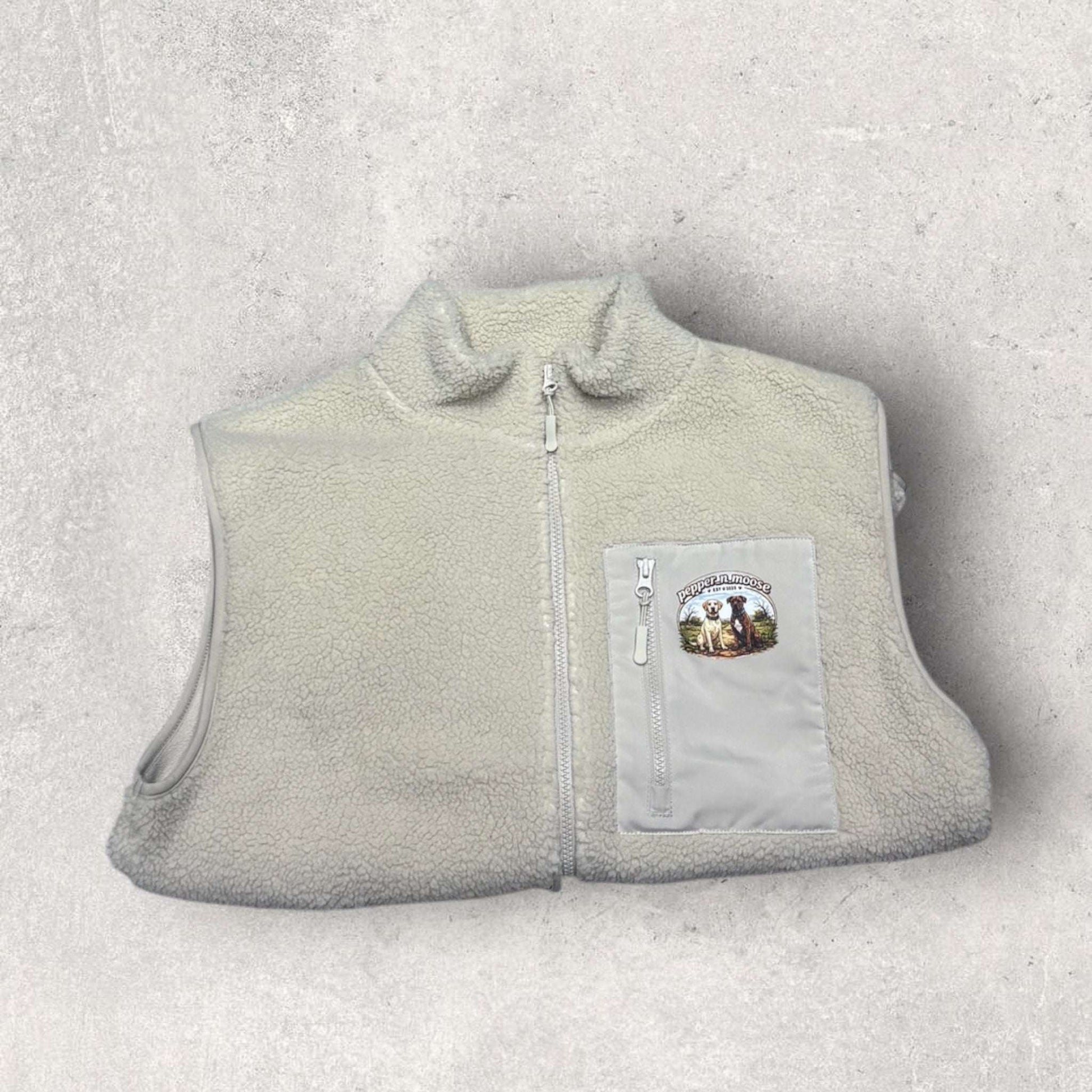 Light gray fleece gilet with a patch on a light gray background
