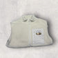 Light gray fleece gilet with a patch on a light gray background