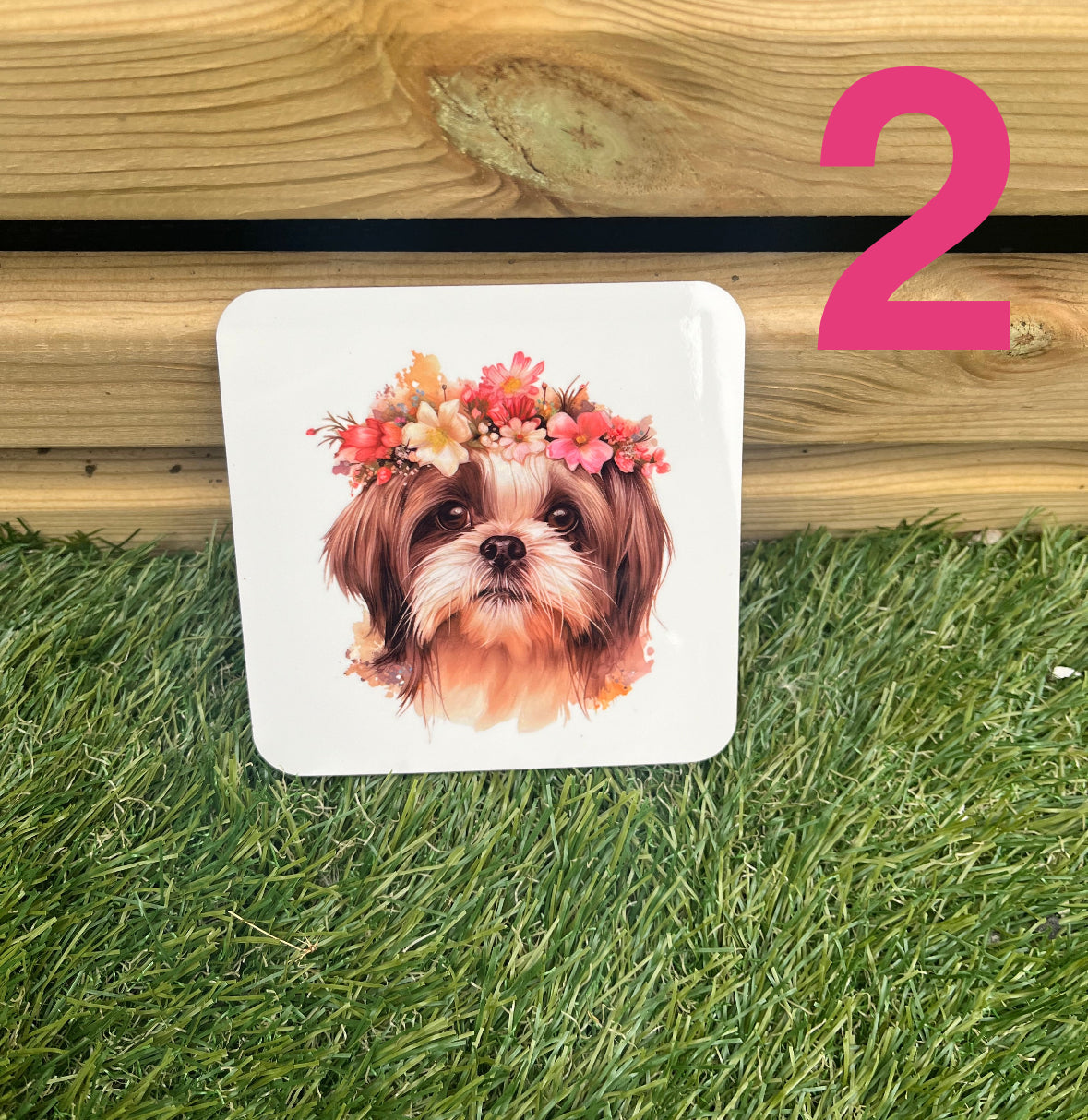 Coaster with a dog wearing a floral crown on grass next to wooden planks