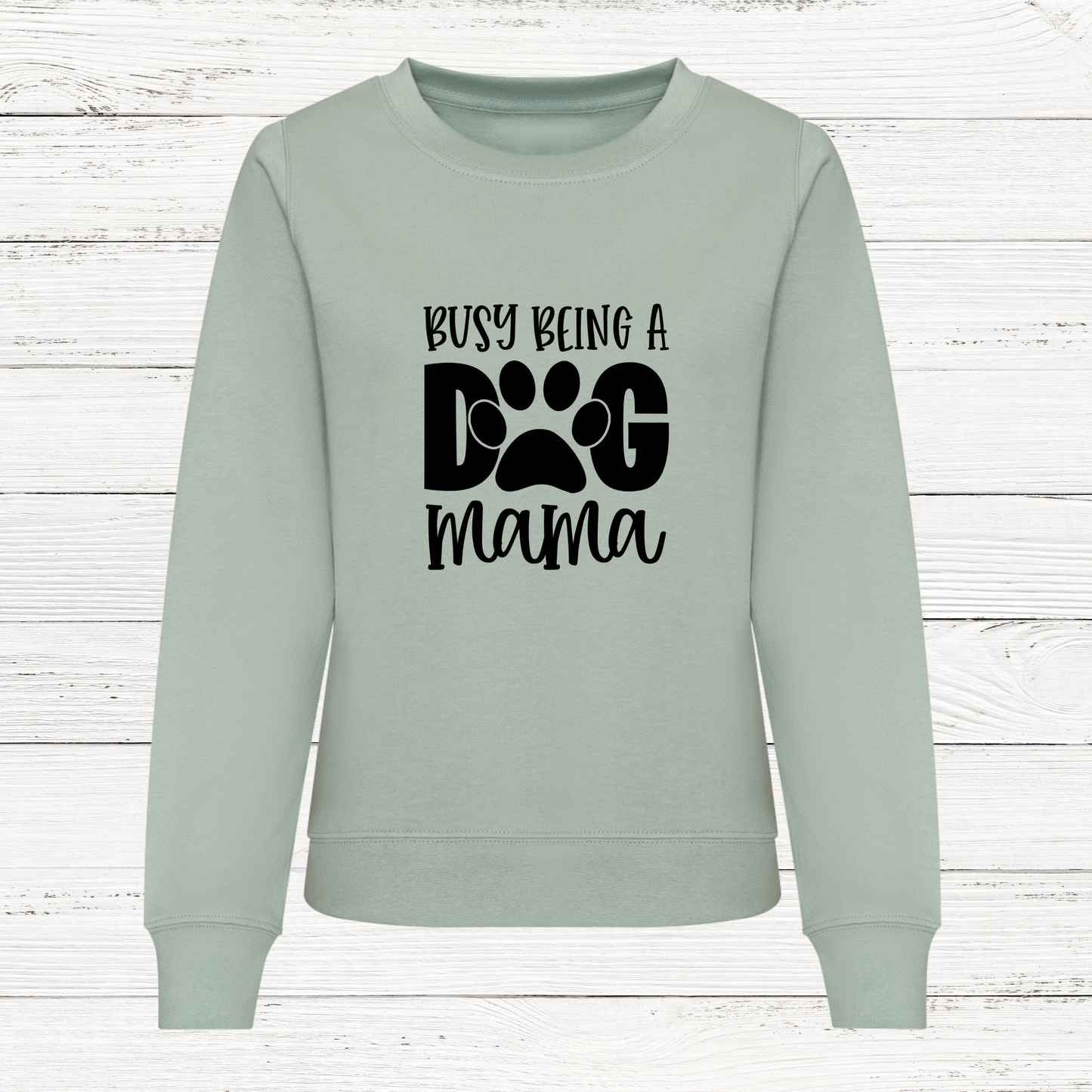 Light green sweatshirt with 'Busy Being a Dog Mama' text on a white wooden background