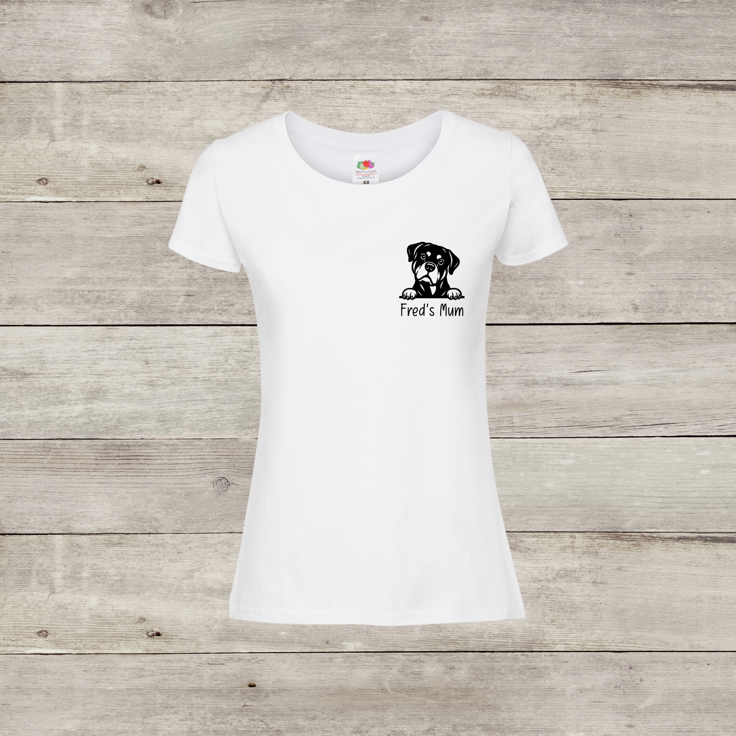 White t-shirt with a dog graphic and text on a wooden surface