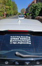 Car with D.G.E Dog Boarding contact information on a window, parked on a residential street.