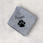 Gray towel with black paw print and 'Raven' text on a light gray background