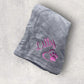 Gray blanket with pink text and heart design on a light gray background