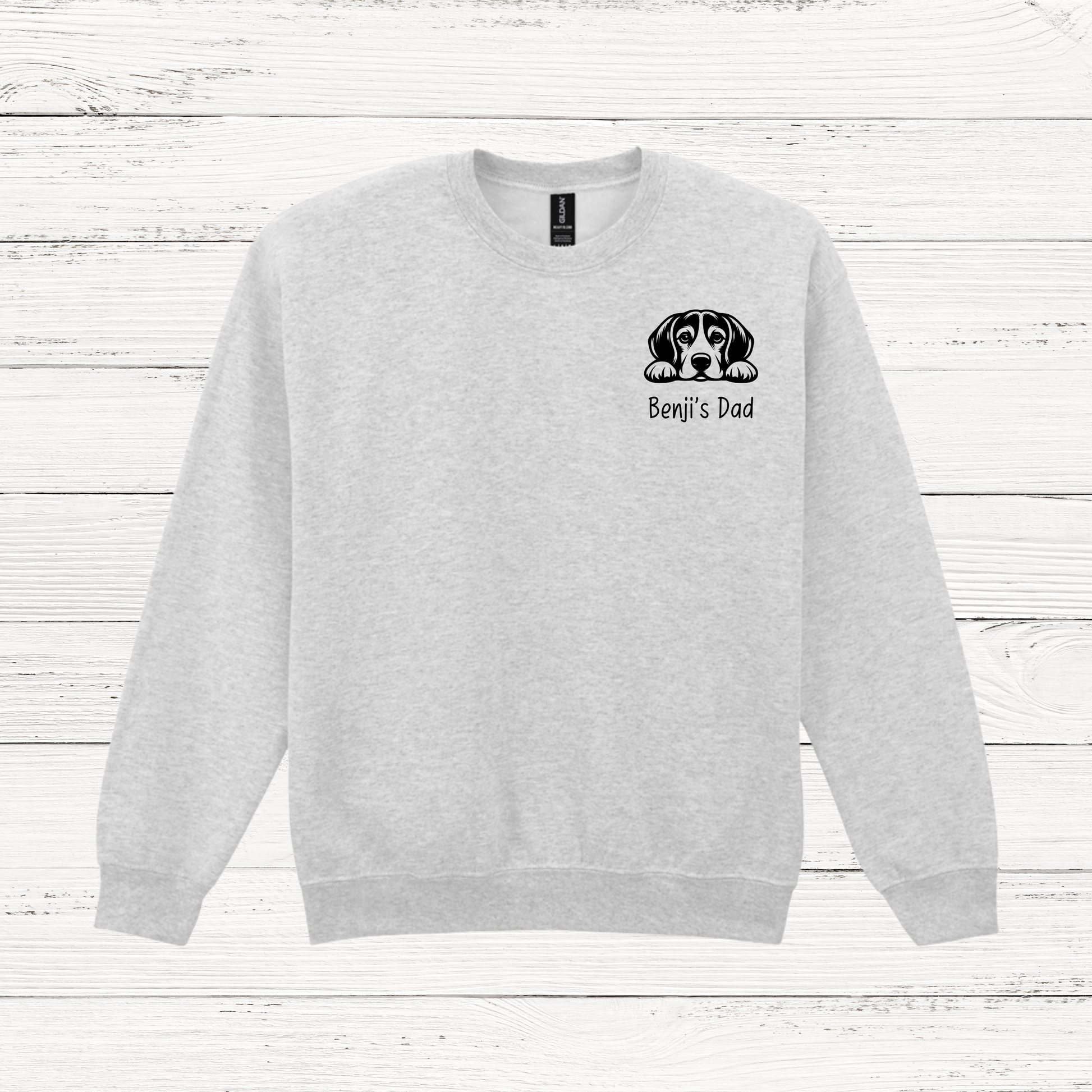 Gray sweatshirt with a dog graphic and text on a white wooden background