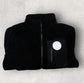 Black jacket with a logo on a light gray background