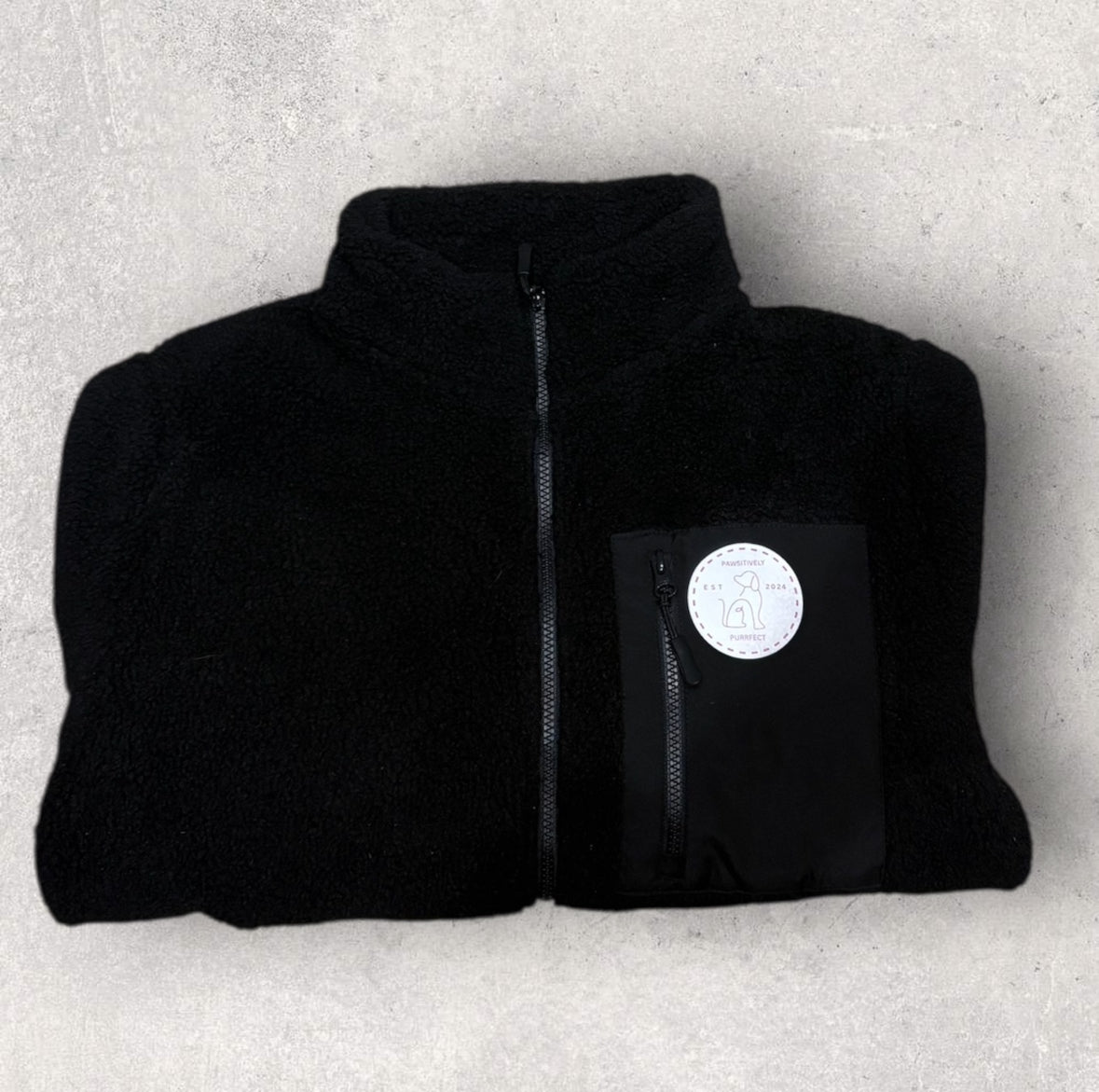 Black jacket with a logo on a light gray background