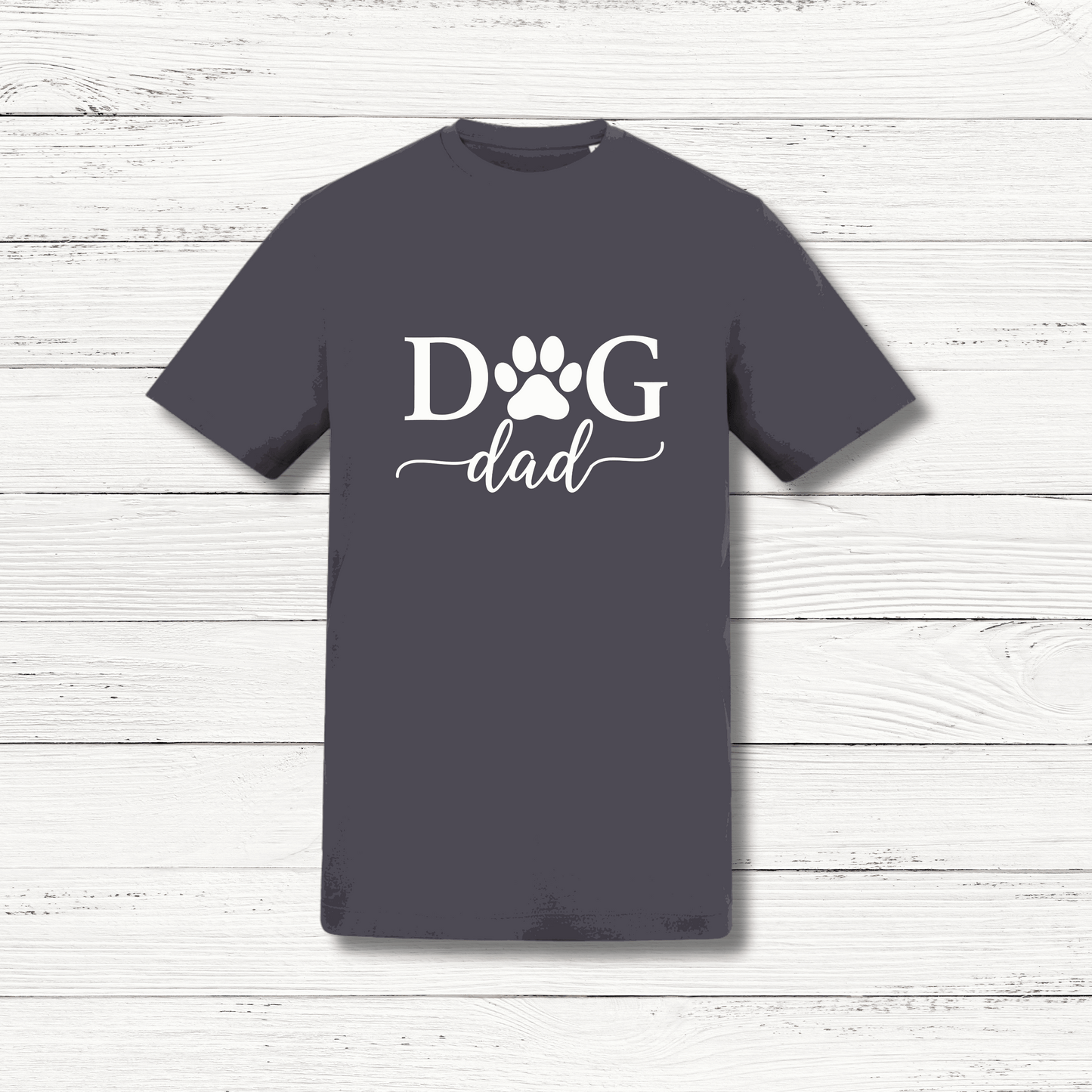 Gray t-shirt with 'Dog Dad' text on a wooden surface