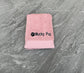 Pink towel with 'Mucky Pup' text on a gray surface