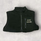Black fleece gilet with 'Farmer Emmadee' text on a light gray background