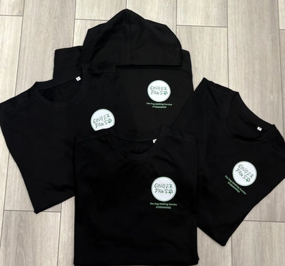 Black hoodies with a circular logo on a wooden floor
