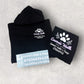 Black hoodie and carl vinyl with 'Emma's Walk & Stay' branding on a light gray background