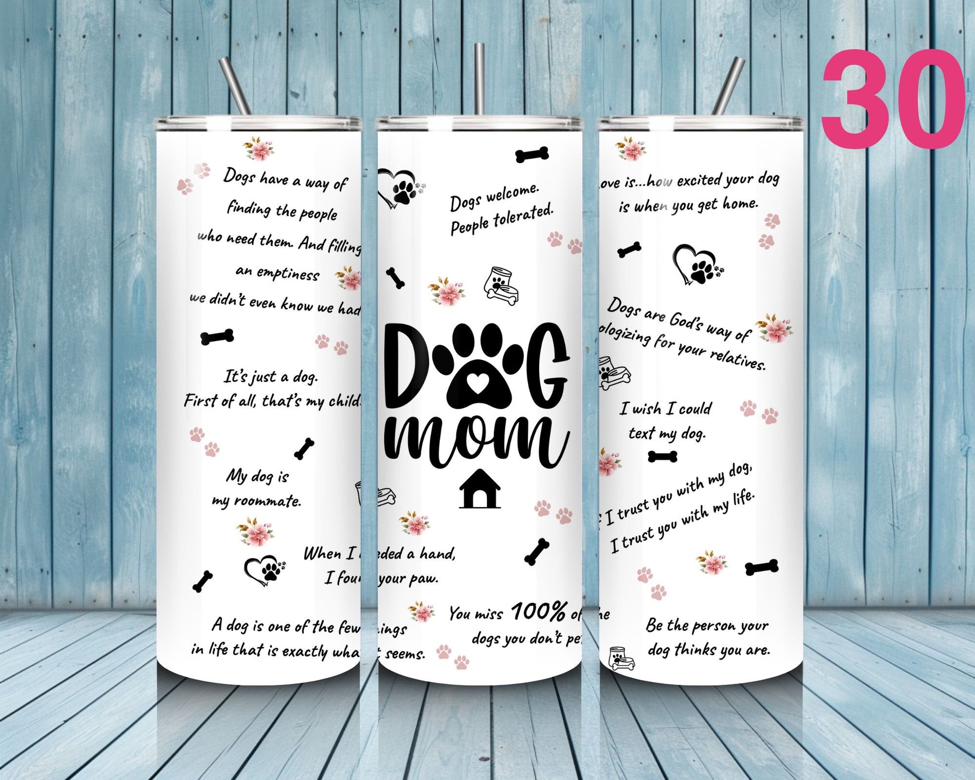 Three tumblers with text and dog-themed graphics on a wooden floor and blue wooden wall background.