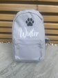 Gray backpack with a paw print and 'Winter' text on a wooden background