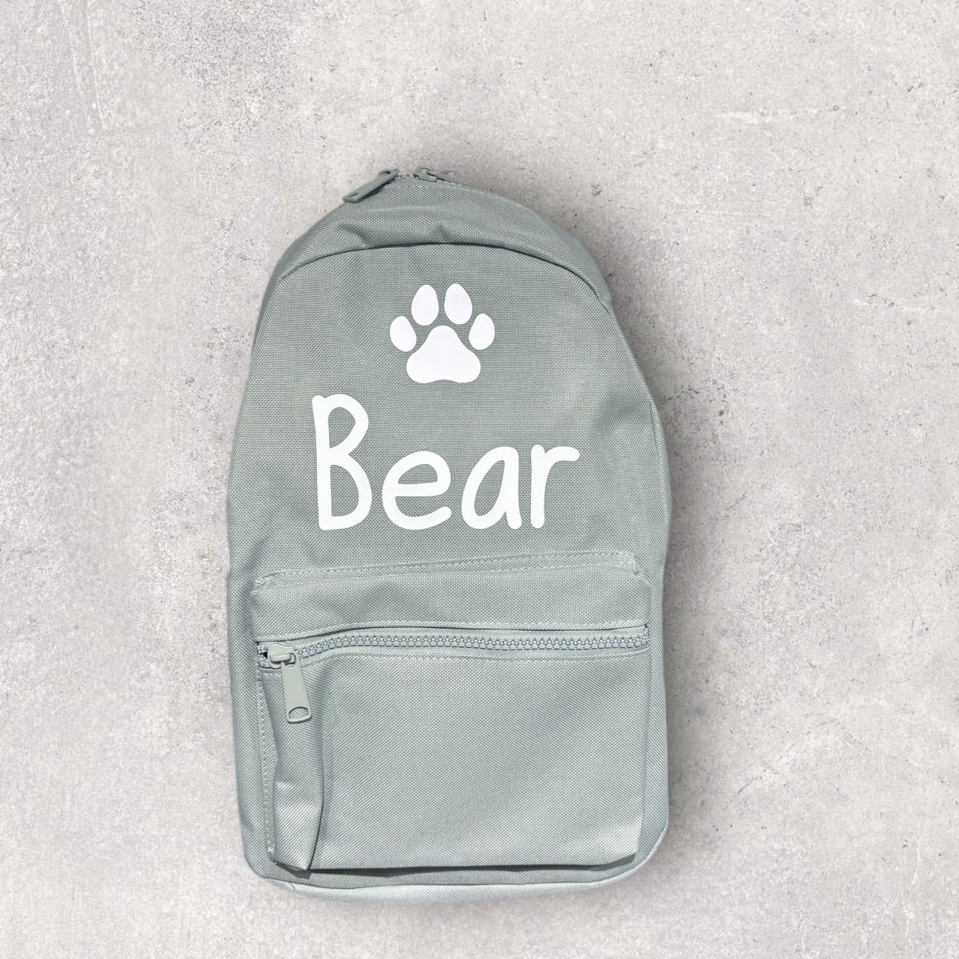 Gray backpack with 'Bear' and a paw print on a light gray background