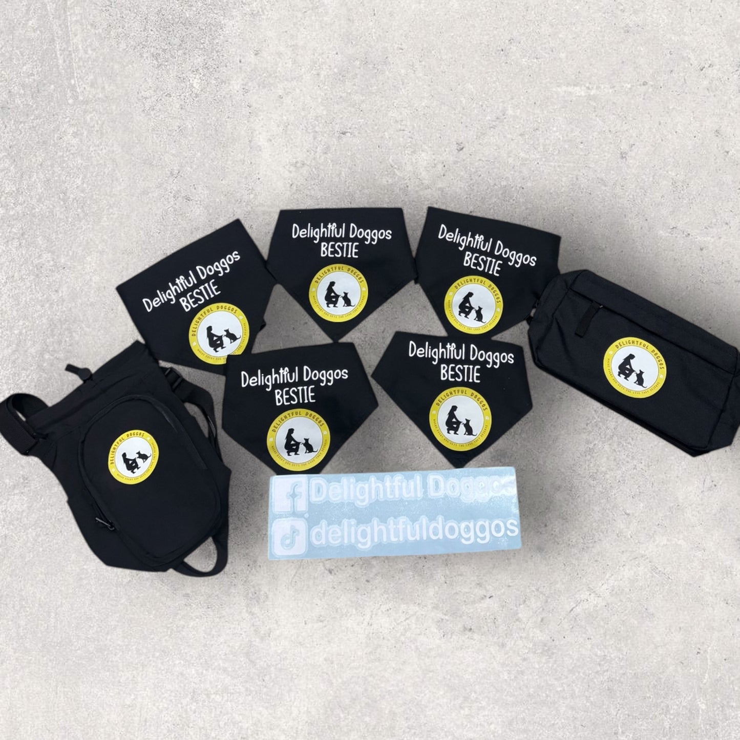Set of black dog bandanas with 'Delightful Doggos Bestie' labels on a gray surface