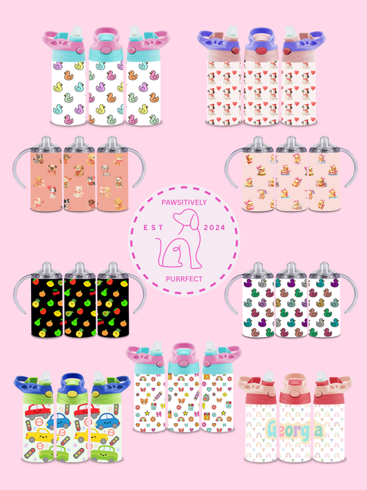 Collection of children's sippy cups with various patterns on a pink background