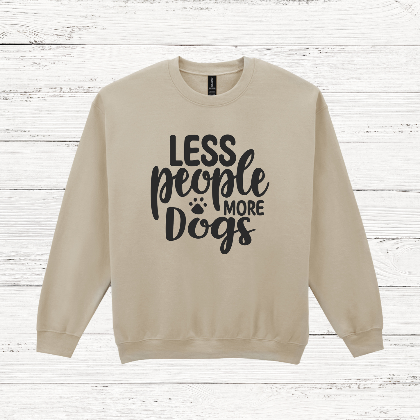 Beige sweatshirt with 'LESS people MORE Dogs' text on a wooden background
